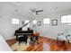 Light-filled room featuring beautiful hardwood floors, large windows, and grand piano at 8044 E 24Th Ave, Denver, CO 80238