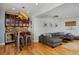 Open-concept living area features a bar with glass-front cabinets, modern decor, and large sectional seating at 8044 E 24Th Ave, Denver, CO 80238