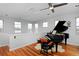 Light-filled room featuring beautiful hardwood floors, large windows, and grand piano at 8044 E 24Th Ave, Denver, CO 80238