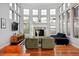 Bright living room with soaring ceilings, large windows, hardwood flooring, and fireplace at 8044 E 24Th Ave, Denver, CO 80238