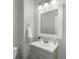 Simple bathroom with gray vanity and white framed mirror at 1428 S De Gaulle Ct, Aurora, CO 80018