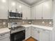 Modern kitchen with stainless steel appliances and white cabinets at 1428 S De Gaulle Ct, Aurora, CO 80018