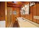 Bathroom with tile shower, wooden walls, light colored vanity and sink, with views from window at 121 Mary Beth Rd, Evergreen, CO 80439