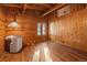 Bedroom with wooden walls and ceiling, wood flooring, window and light with a view of the outdoors at 121 Mary Beth Rd, Evergreen, CO 80439