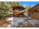 Exterior view of a wooden shed-style building with a small deck and snow on the ground at 121 Mary Beth Rd, Evergreen, CO 80439