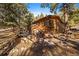 Charming log cabin with wood deck and stone foundation, set amidst a tranquil wooded landscape at 121 Mary Beth Rd, Evergreen, CO 80439