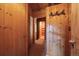 Hallway leading to lower level of home with wood walls and trim, and carpet flooring at 121 Mary Beth Rd, Evergreen, CO 80439