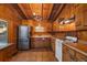 Rustic wood kitchen features tile floors, stainless steel refrigerator, and classic cabinetry at 121 Mary Beth Rd, Evergreen, CO 80439