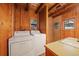 Laundry room featuring wood-paneled walls, washer, dryer, and sink at 121 Mary Beth Rd, Evergreen, CO 80439