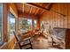 Bright sunroom with wood-paneled walls, hardwood floors, mountain views, and rustic decor at 121 Mary Beth Rd, Evergreen, CO 80439