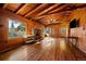 Bright living room with wood floors, stone fireplace, and large windows offering scenic views at 121 Mary Beth Rd, Evergreen, CO 80439