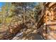 View of patio with wood storage, stone stairs, and outdoor fireplace at 121 Mary Beth Rd, Evergreen, CO 80439