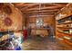 Workshop featuring wood paneled walls, work bench, shelving, and wood flooring at 121 Mary Beth Rd, Evergreen, CO 80439