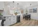 Stylish modern kitchen features an island with wine cooler, white countertops, and a cozy dining area at 3541 Eudora St, Denver, CO 80207