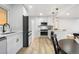 Updated kitchen with stone backsplash, stainless appliances, and wood-look floors at 3541 Eudora St, Denver, CO 80207
