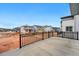 View of the backyard concrete patio with black metal railing and other homes with a view of construction nearby at 7267 Prairie Sage Pl, Littleton, CO 80125