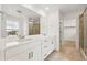 Bathroom featuring double sinks, quartz countertops, and glass-enclosed shower at 7267 Prairie Sage Pl, Littleton, CO 80125
