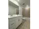 Bright bathroom featuring a double sink vanity with white cabinets, tiled floor and a bath-shower combination at 7267 Prairie Sage Pl, Littleton, CO 80125