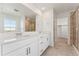 Bathroom featuring dual sinks, walk-in shower and a large mirror at 7267 Prairie Sage Pl, Littleton, CO 80125