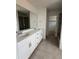 Bathroom featuring a double sink vanity, tile flooring, and a glass-enclosed shower, offering modern comfort and style at 7267 Prairie Sage Pl, Littleton, CO 80125