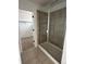 Tiled shower with glass door, and a glimpse into the walk-in closet. Offers simple elegance and practicality at 7267 Prairie Sage Pl, Littleton, CO 80125