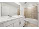 Well-lit bathroom featuring double sinks, a large mirror, and a shower-tub combination with decorative tile, perfect for modern living at 7267 Prairie Sage Pl, Littleton, CO 80125
