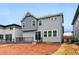 Two-story home featuring gray horizontal and vertical siding with white-trimmed windows and a backyard ready for landscaping at 7267 Prairie Sage Pl, Littleton, CO 80125