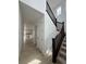 Hallway with view into the kitchen, featuring wooden floors and a staircase with dark railings, leading to the upper level at 7267 Prairie Sage Pl, Littleton, CO 80125