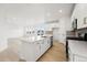 Modern white kitchen with a large island, stainless appliances and wood flooring at 7267 Prairie Sage Pl, Littleton, CO 80125