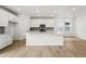 Modern kitchen featuring white cabinets, stainless steel appliances, and an island with quartz countertops at 7267 Prairie Sage Pl, Littleton, CO 80125