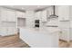 Spacious kitchen with stainless steel appliances, white cabinets, countertops, and center island at 7267 Prairie Sage Pl, Littleton, CO 80125