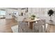 Spacious kitchen and dining area with white cabinets, island, and wood flooring at 7267 Prairie Sage Pl, Littleton, CO 80125