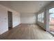 Spacious living room with hardwood floors, large windows, and a sliding glass door, offering ample natural light at 7267 Prairie Sage Pl, Littleton, CO 80125
