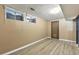 Finished basement with wood-look flooring, a new door, and natural light from the window at 6795 E Arizona Ave # B, Denver, CO 80224