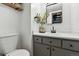 Well-lit bathroom with a gray vanity, modern fixtures, and a decorative mirror at 6795 E Arizona Ave # B, Denver, CO 80224