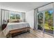 Bright primary bedroom with large windows, and access to a deck with outdoor seating at 6795 E Arizona Ave # B, Denver, CO 80224