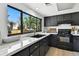 Modern kitchen featuring black cabinets, marble countertops, gold hardware, and stainless steel appliances at 6795 E Arizona Ave # B, Denver, CO 80224