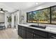 Bright kitchen with black cabinets, marble counters, large window, and an adjacent dining area at 6795 E Arizona Ave # B, Denver, CO 80224