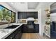 Modern kitchen with black cabinets, marble countertops, gold hardware, and a large window at 6795 E Arizona Ave # B, Denver, CO 80224