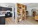 Open-concept living area with hardwood floors, fireplace, bookshelf room divider, and modern kitchen at 6795 E Arizona Ave # B, Denver, CO 80224
