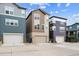 A low-angle shot of various townhomes with driveway and garage, and neutral paint at 8883 Ramblestone St, Highlands Ranch, CO 80129