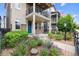 Charming front entrance featuring a blue door, lush landscaping, and a welcoming walkway at 8883 Ramblestone St, Highlands Ranch, CO 80129