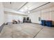 A spacious garage with white walls, concrete flooring, and ample storage space at 8883 Ramblestone St, Highlands Ranch, CO 80129
