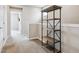 Hallway featuring shelf and black metal basket with neutral walls and carpet at 8883 Ramblestone St, Highlands Ranch, CO 80129