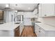 Contemporary white kitchen with stainless steel appliances and a large island with bar stool seating at 8883 Ramblestone St, Highlands Ranch, CO 80129