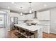 Bright modern kitchen featuring white cabinets, stainless steel appliances and a large center island with bar stool seating at 8883 Ramblestone St, Highlands Ranch, CO 80129