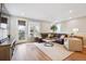 Inviting living room with wood floors, a large leather sectional and lots of natural light at 8883 Ramblestone St, Highlands Ranch, CO 80129