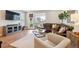 Inviting living room with wood floors, a large leather sectional and lots of natural light at 8883 Ramblestone St, Highlands Ranch, CO 80129