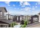 An eye-level shot of homes with neutral colors, clear blue skies, and snow-capped mountains in the background at 8883 Ramblestone St, Highlands Ranch, CO 80129