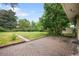 Large backyard featuring a brick patio, lush greenery, and a storage shed for outdoor storage at 3054 S Raleigh St, Denver, CO 80236